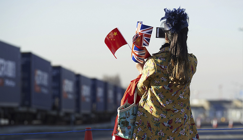 The train's arrival attracted a crowd of onlookers, including this woman who celebrated the new connection with both countries' flags.