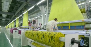 A worker operating textile machinery in a factory