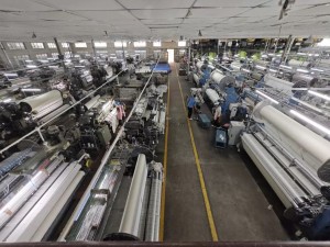 Aerial view of a textile factory with numerous weaving machines and workers