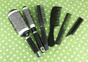 Black hair brushes and combs on green
