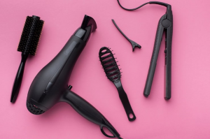 Black hair styling tools on pink background