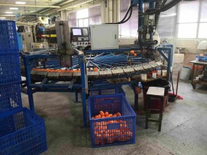Factory machine producing orange objects
