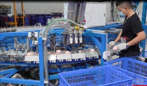 Factory worker operating production machine