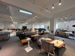 Interior of a spacious furniture store with various sofas, chairs, and tables displayed under bright lighting