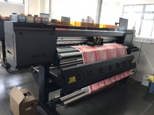 Large - format printer printing a red patterned material in a workshop