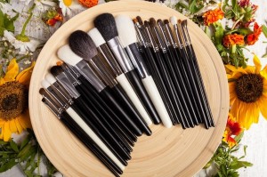 Makeup brushes on wooden plate with flowers