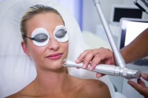 Woman having laser facial treatment