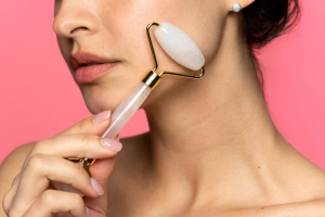 Woman using rose quartz face roller