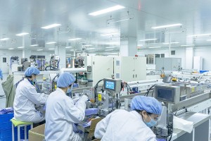 Workers in cleanroom factory operating machines
