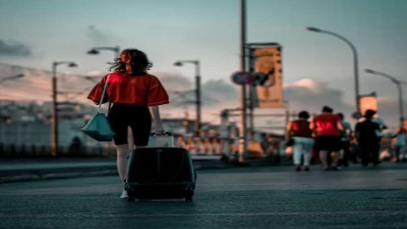 a woman carring a black luggage