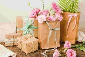 paper-bag-full-fresh-flowers-wrapped-present-gift-wooden-surface